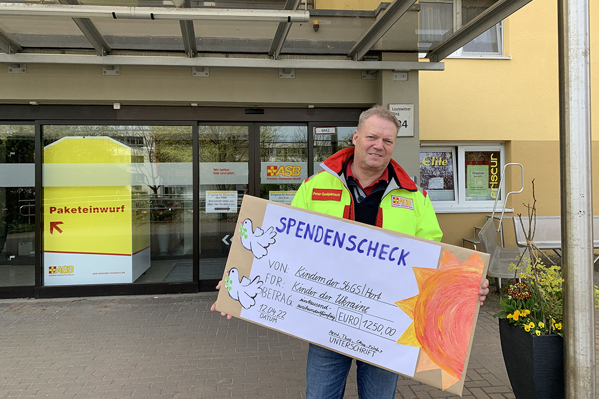Geschäftsführer Peter Großpietsch nimmt einen Spendenscheck entgegegen.