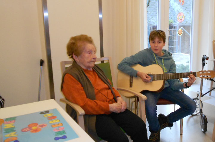 Denis ueberrascht mit seiner Gitarre seine Uroma