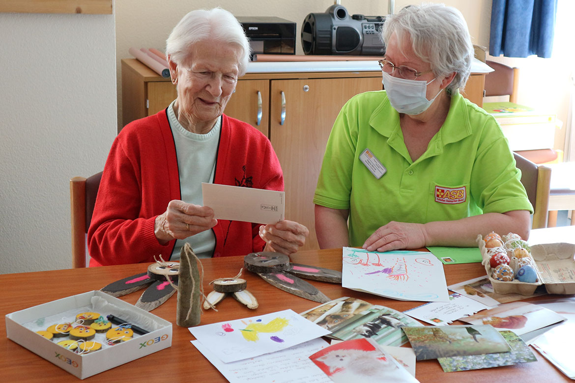 Bewohnerin Elfriede Wilhelm liest mit Betreuungsassistentin Regine Boehme Osterpost_HKB_web©ASB Dresden & Kamenz.jpg